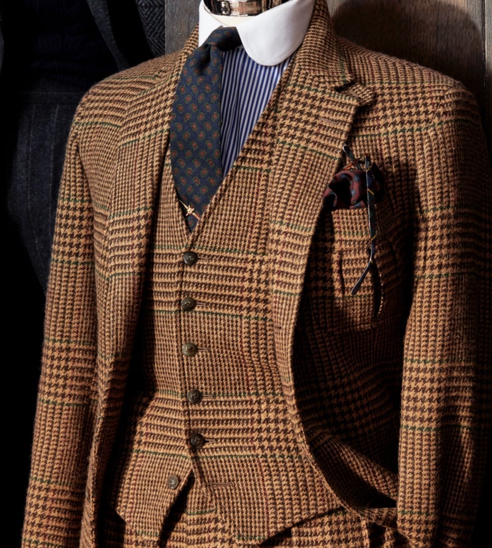 <strong>CHECKED OUT</strong><br/><span>A three-piece suit in a large-scale cognac-and-camel Glen check. The fabric was not only woven exclusively in Britain for the collection; it has a pattern detail that is purely Polo: a windowpane grid of wine and green &ldquo;guard&rdquo; the pattern, meaning the colours run along the edge of the plaid, giving it the unmistakable look of Ralph Lauren</span>